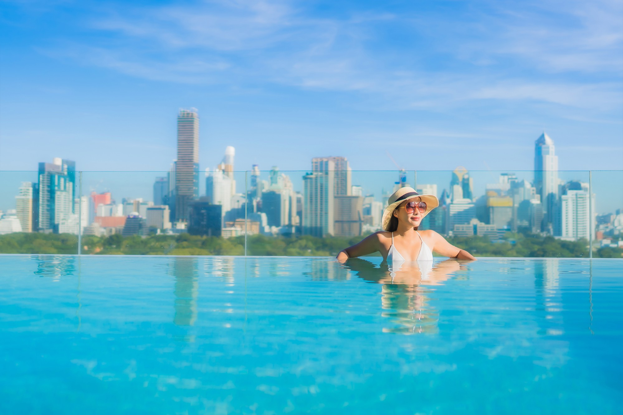 portrait-beautiful-young-asian-woman-smile-relax-leisure-around-outdoor-swimming-pool-with-city-view